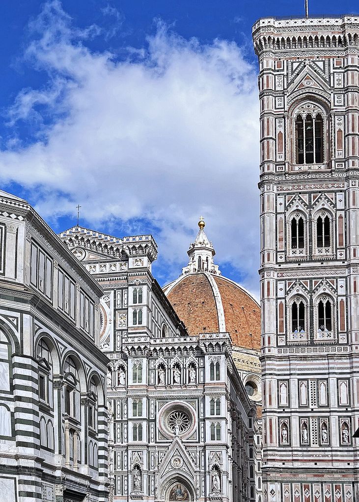 A vast red-tiled dome and white lantern rise behind an ornate marble cathedral façade, with a tall patterned bell tower filling the right edge.