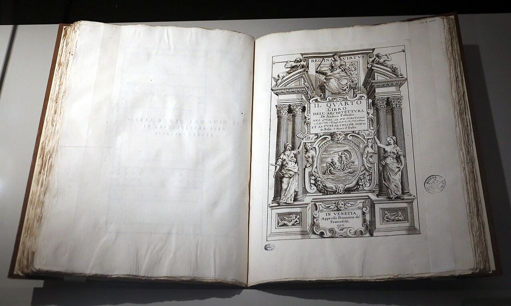 A large bound book lies open to an ornate engraved title page framed by columns, allegorical figures and the printed date 1570.