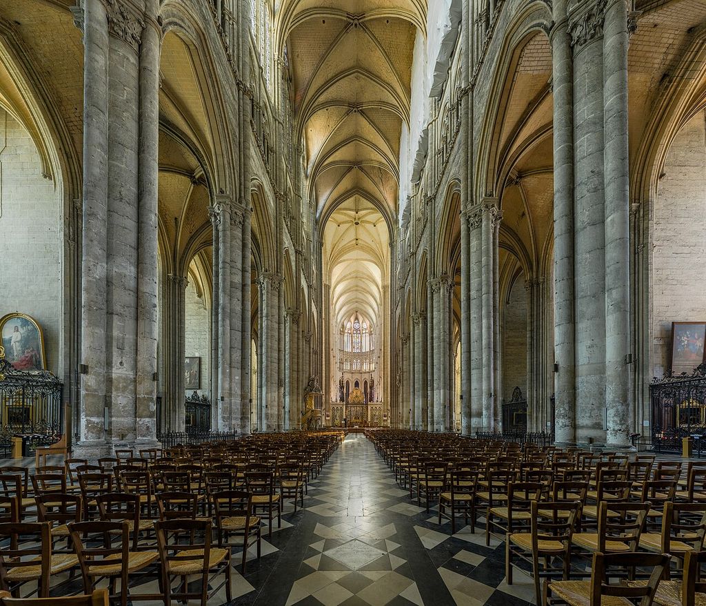 Slender clustered supports rise from pointed arcades toward a ribbed vault and high windows.