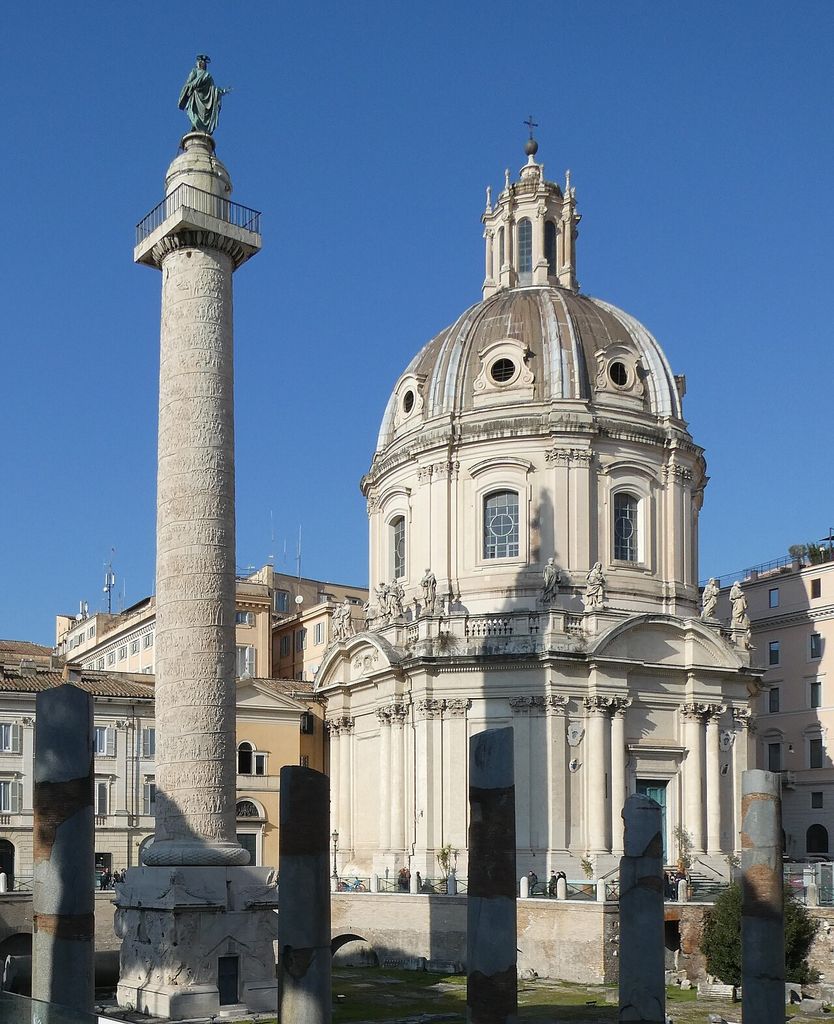 A tall relief-carved column with a pedestal and summit statue stands separately beside a domed church.