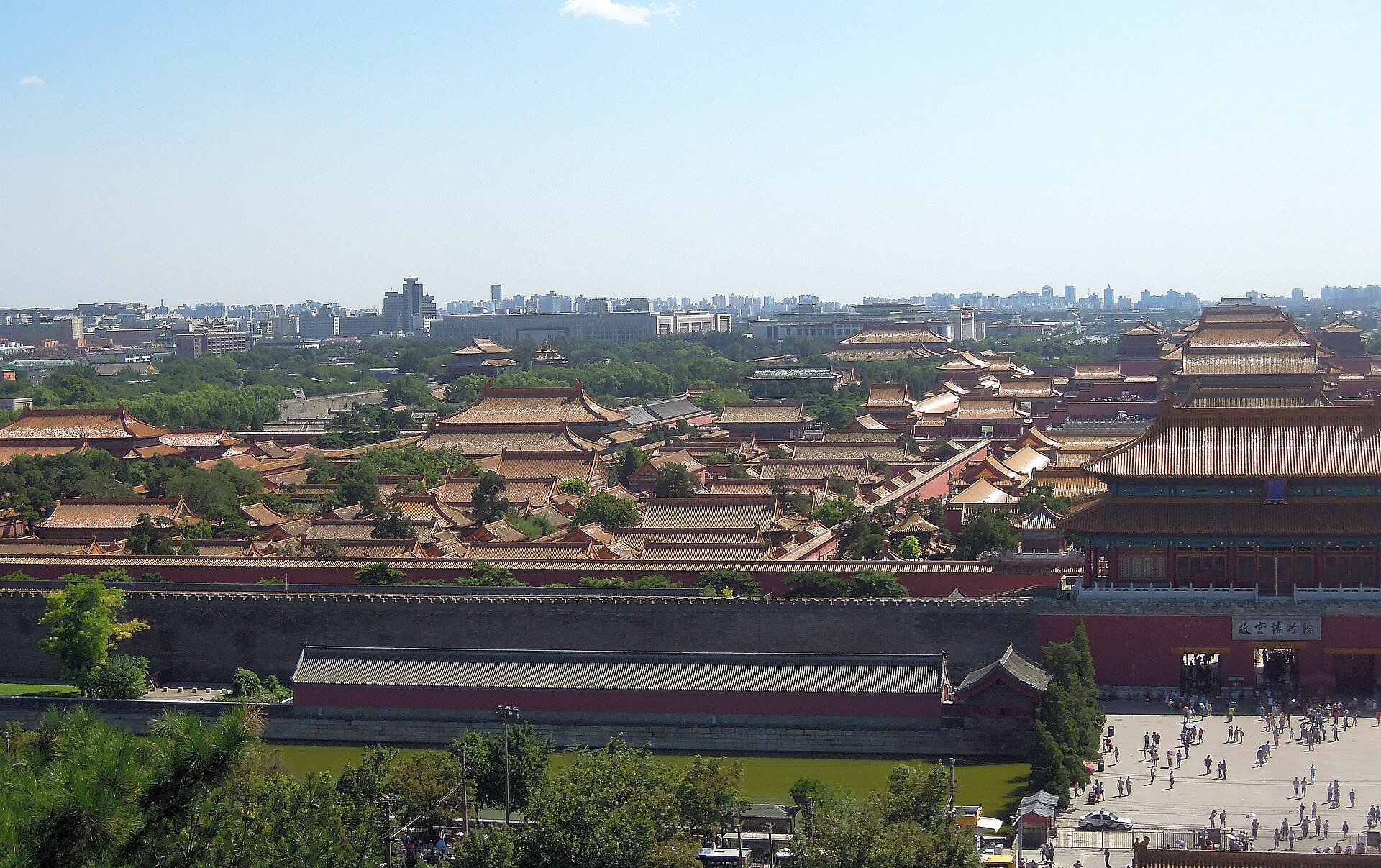 Elevated view of the Forbidden City roofscape with a northern gate, wall, moat and Beijing city beyond.