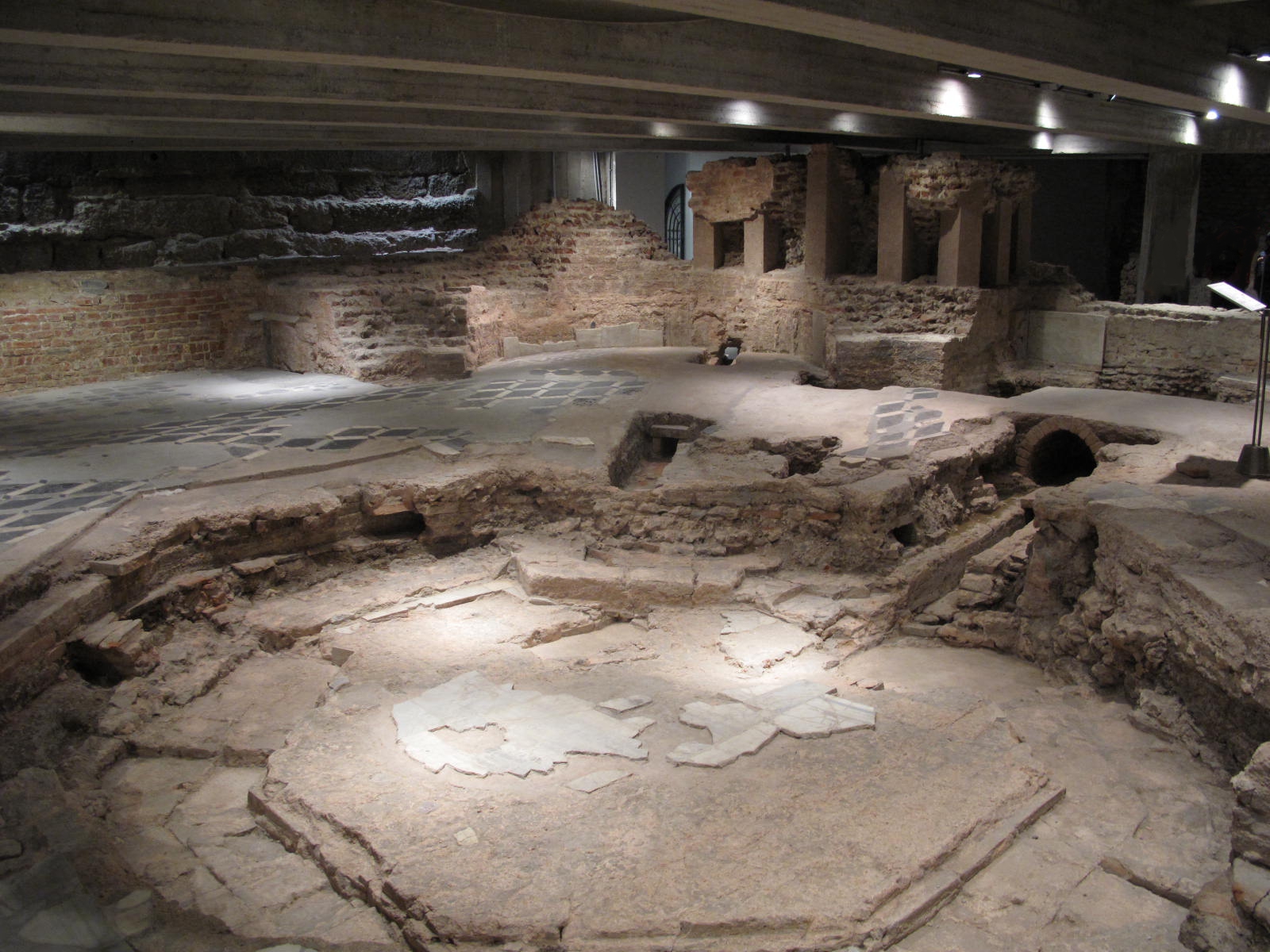 Excavated brick walls, octagonal paving and the immersion-pool remains of San Giovanni alle Fonti beneath Milan Cathedral.