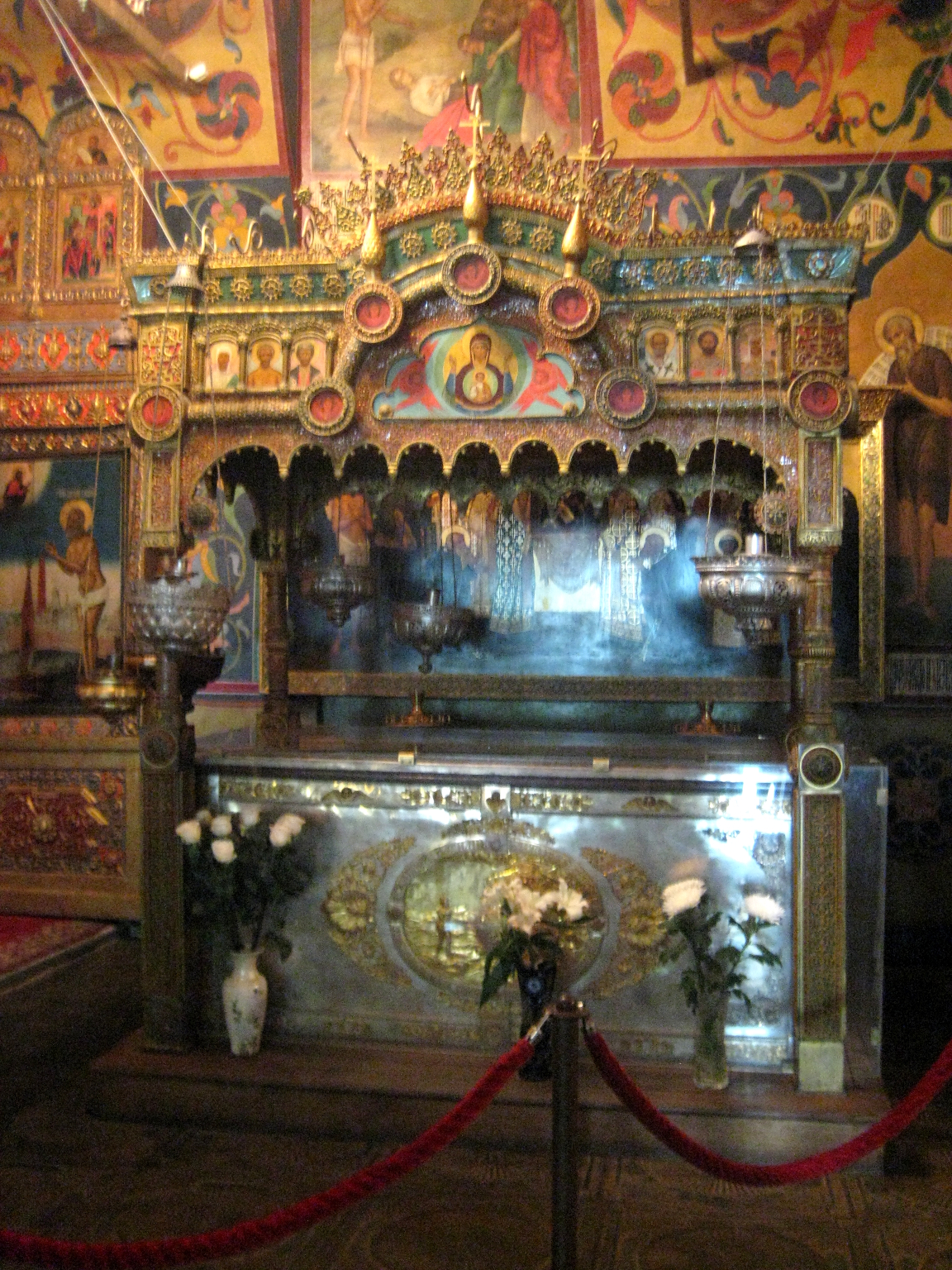 Lower shrine over Basil the Blessed’s grave, with icons, lamps, flowers and present protective glazing.