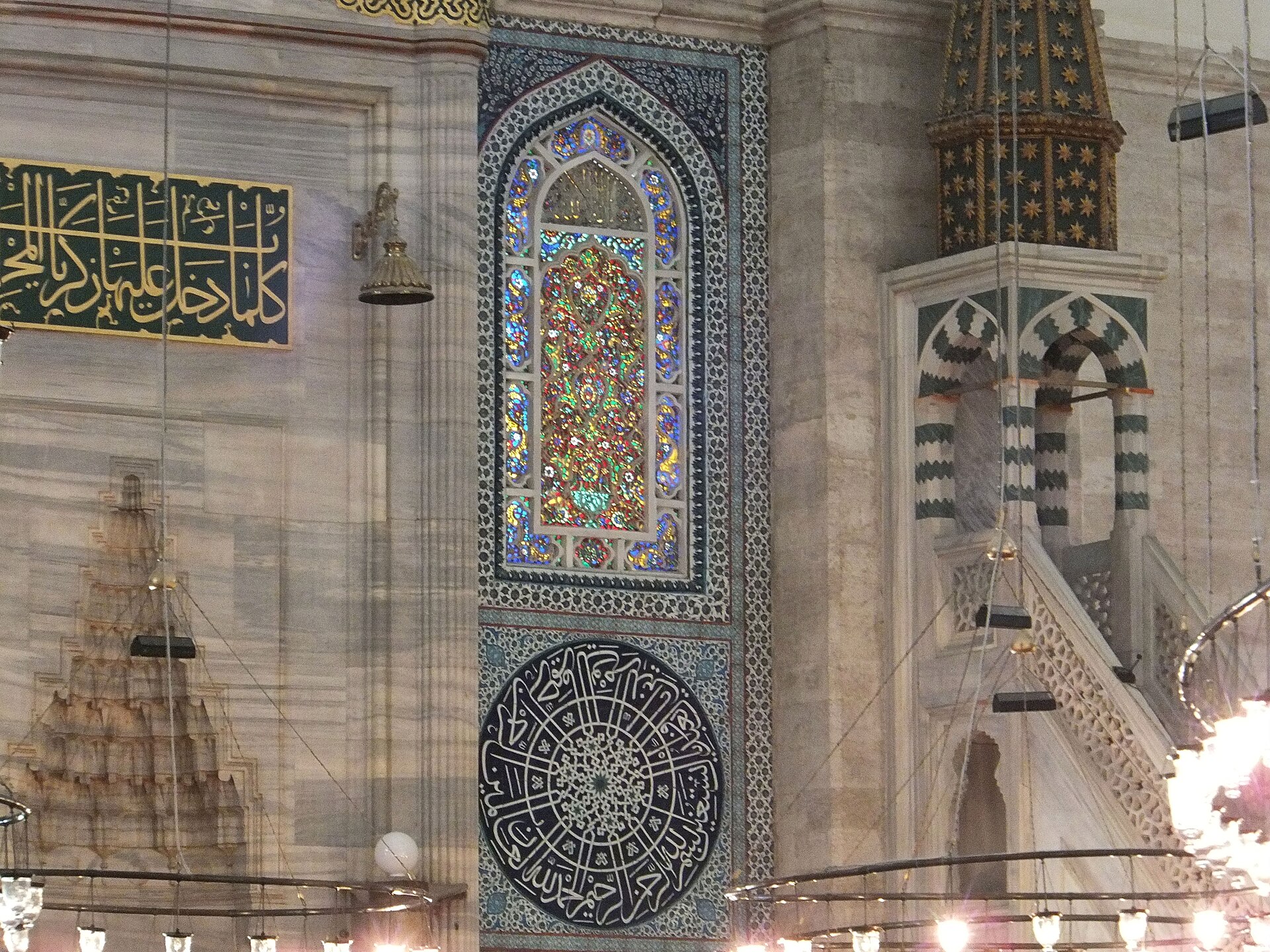 Detail by the mihrab with coloured glass, glazed tile and inscriptions.