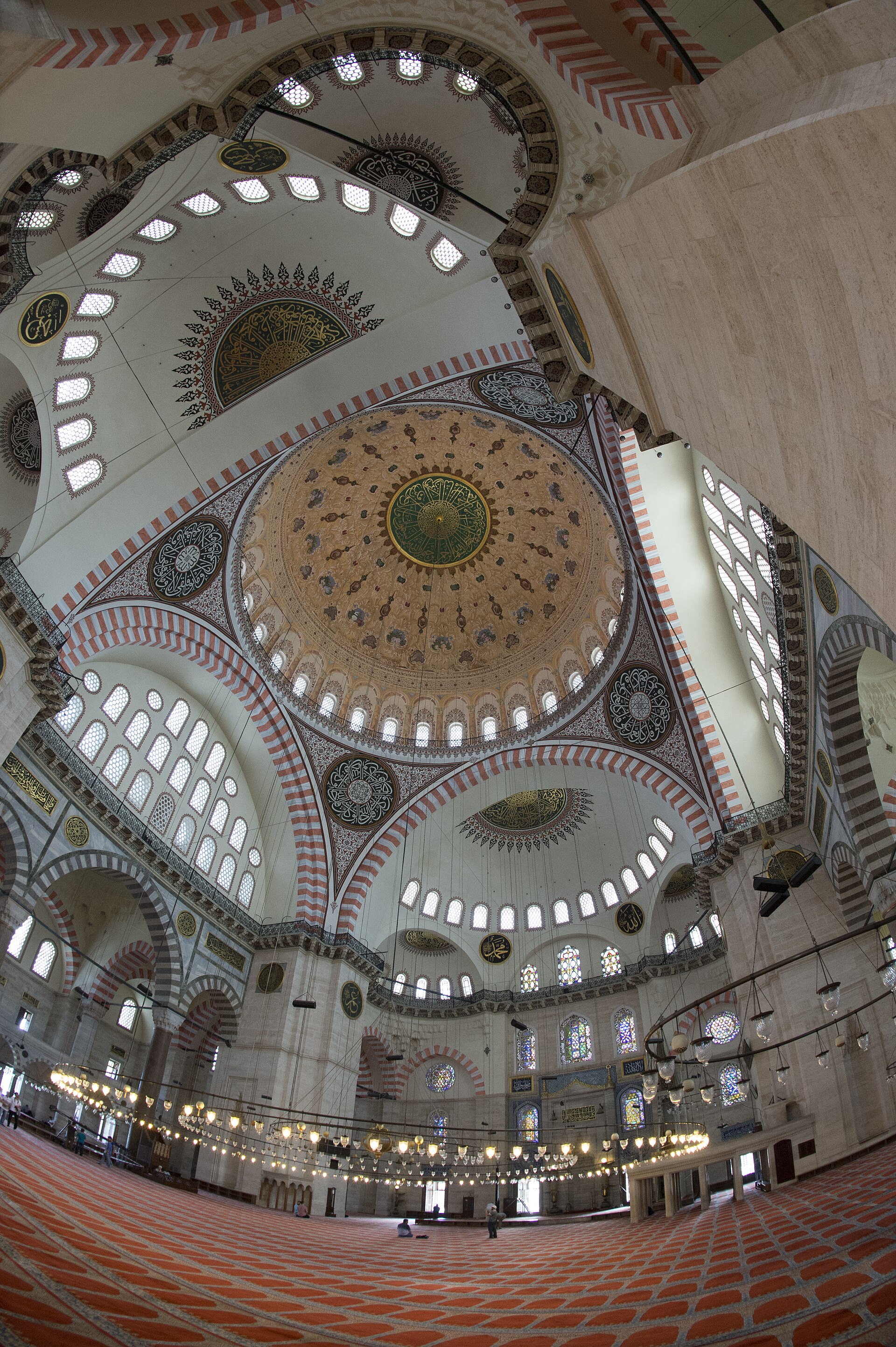 Wide interior of Süleymaniye Mosque showing the central dome, axial half-domes, supports, windows and side galleries.