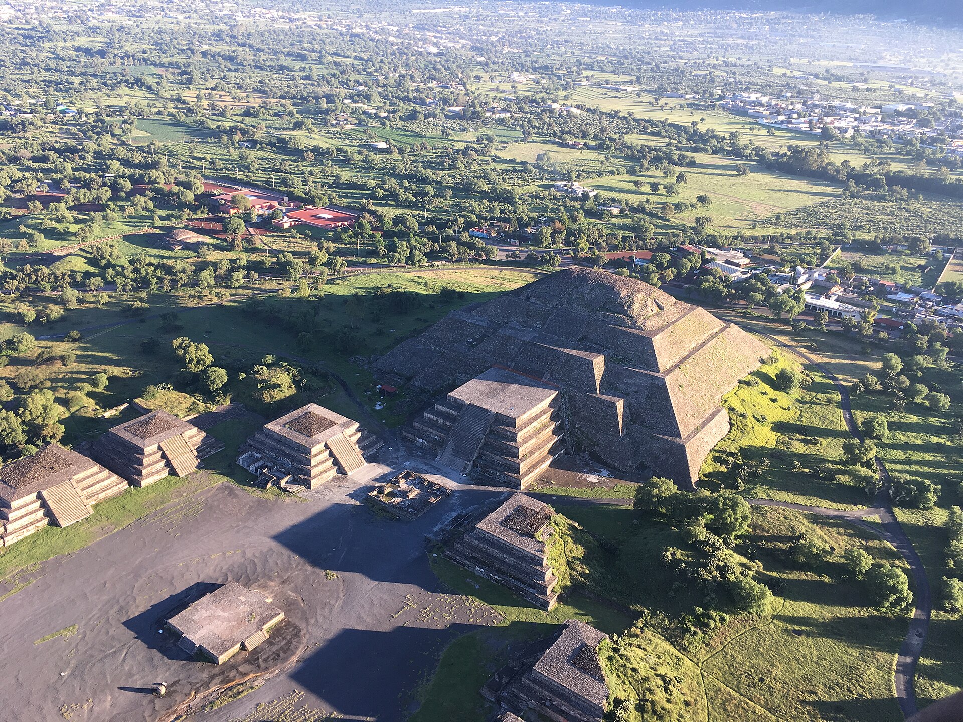 Oblique aerial view of the Sun Pyramid and lower neighbouring stepped structures within the archaeological site.