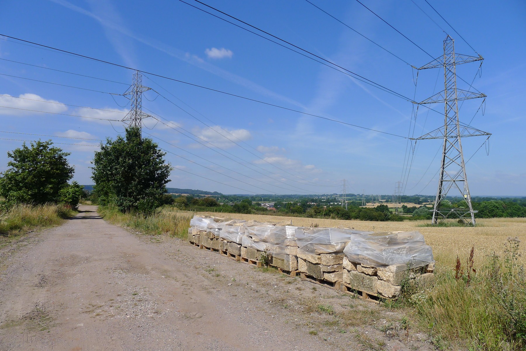 Pallets of stone blocks beside a rural track.