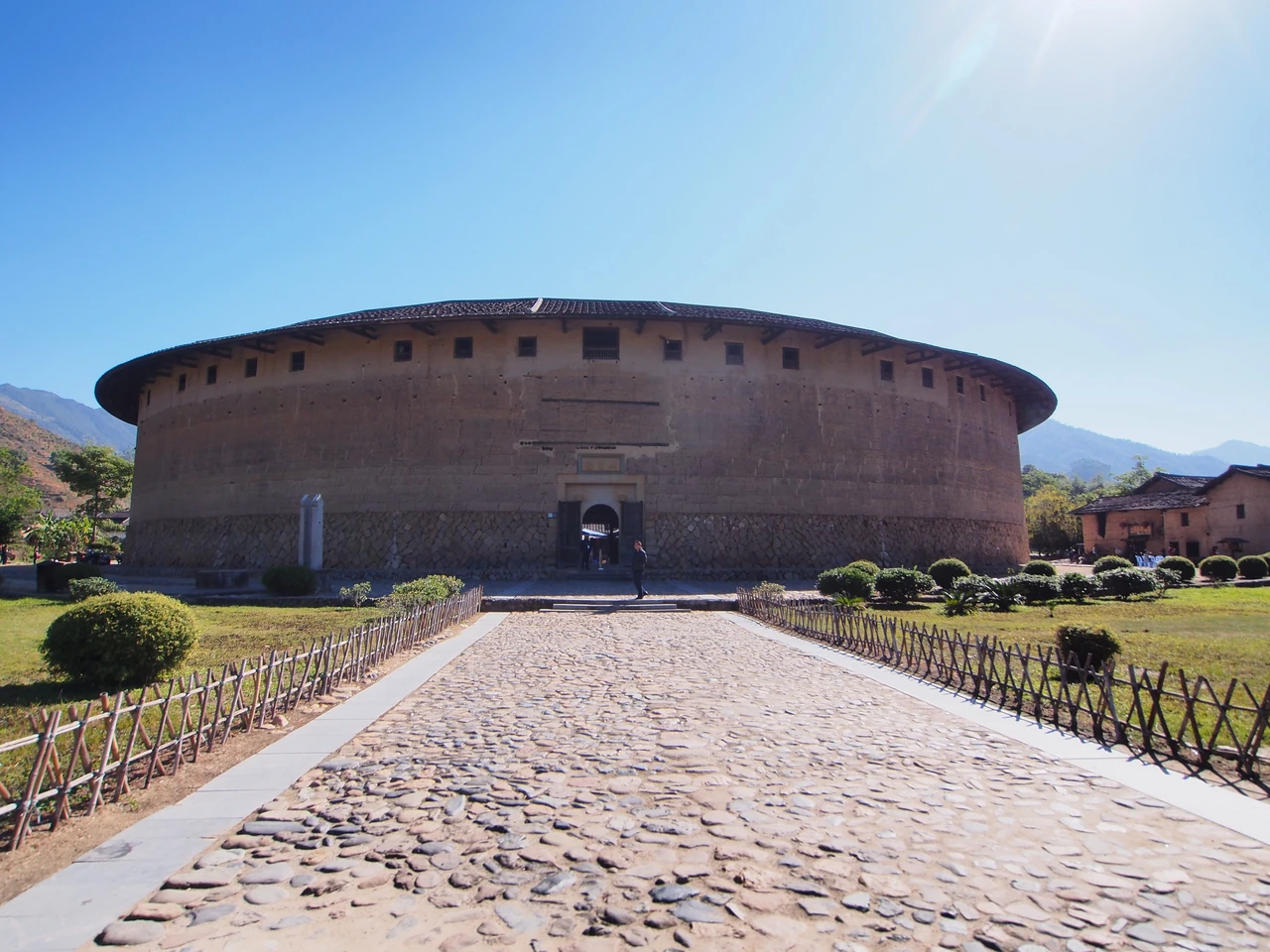 Eryilou's curved earth exterior, stone base, central stone entrance and small upper windows.