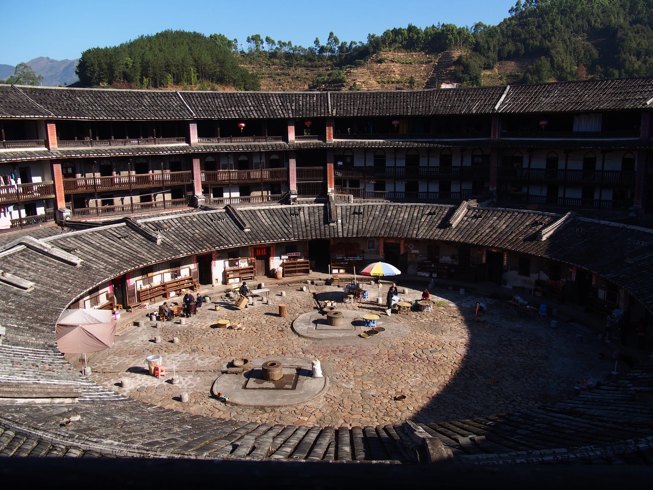 Timber galleries and lower tiled roofs surrounding Eryilou's paved shared courtyard.
