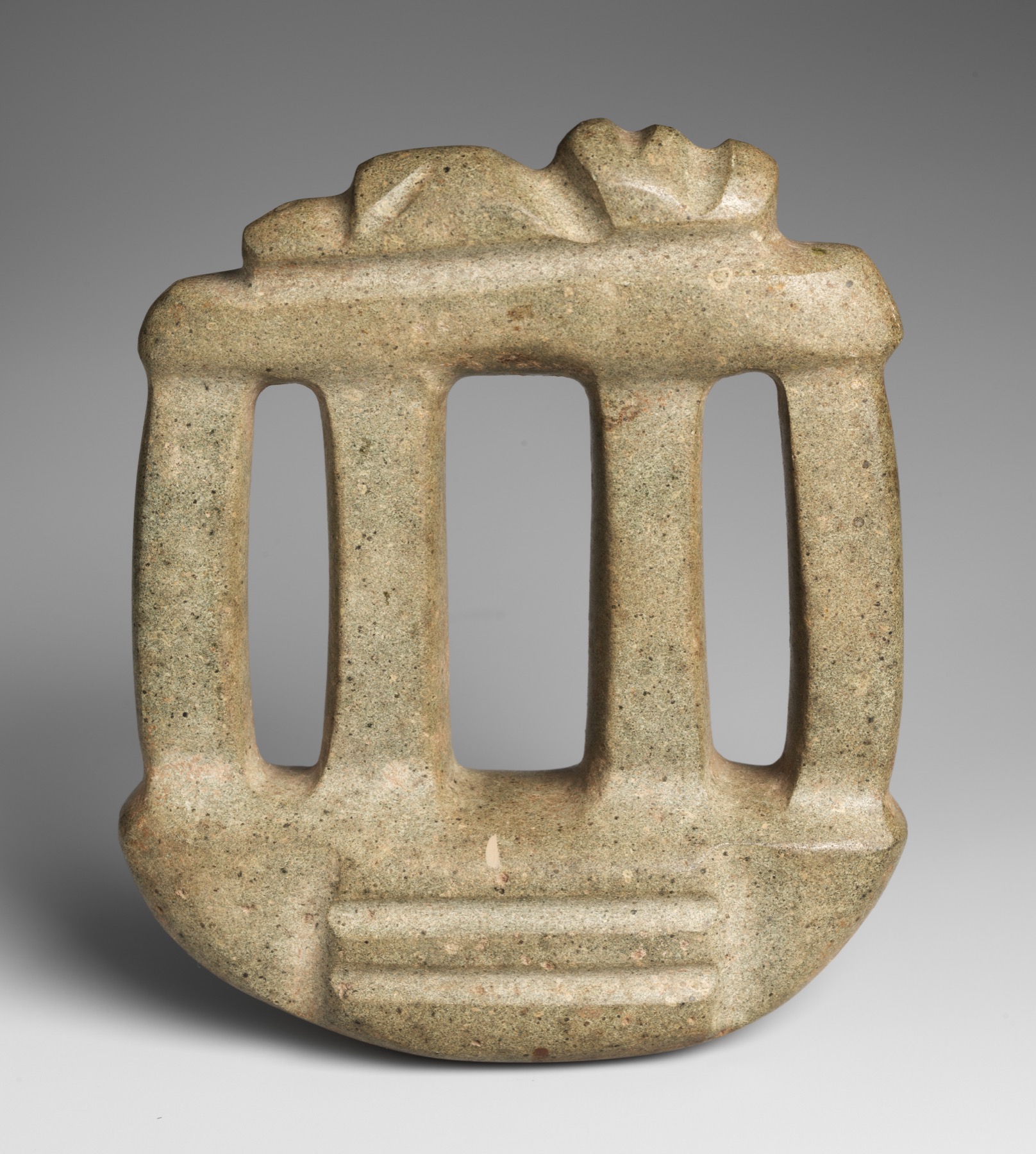 Greenstone carving with three open column-like gaps, central stair and low pitched outline.
