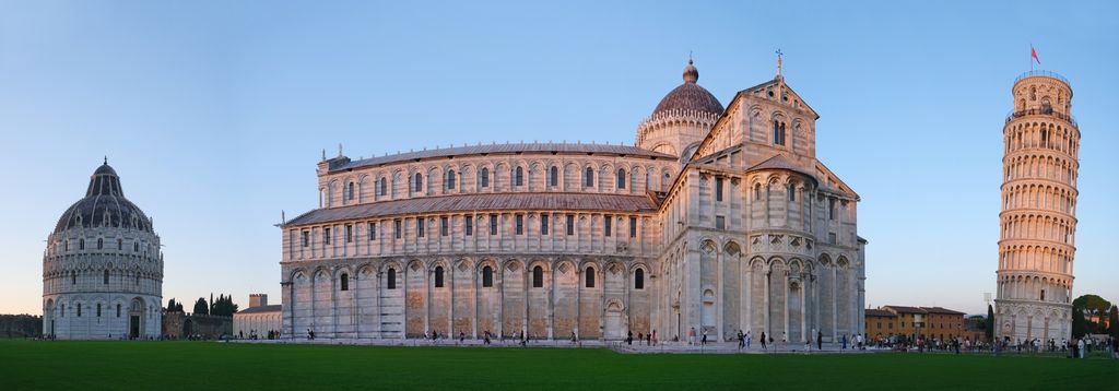 A round domed baptistery stands apart from the long cathedral and its crossing dome, with the separate leaning bell tower to the right.