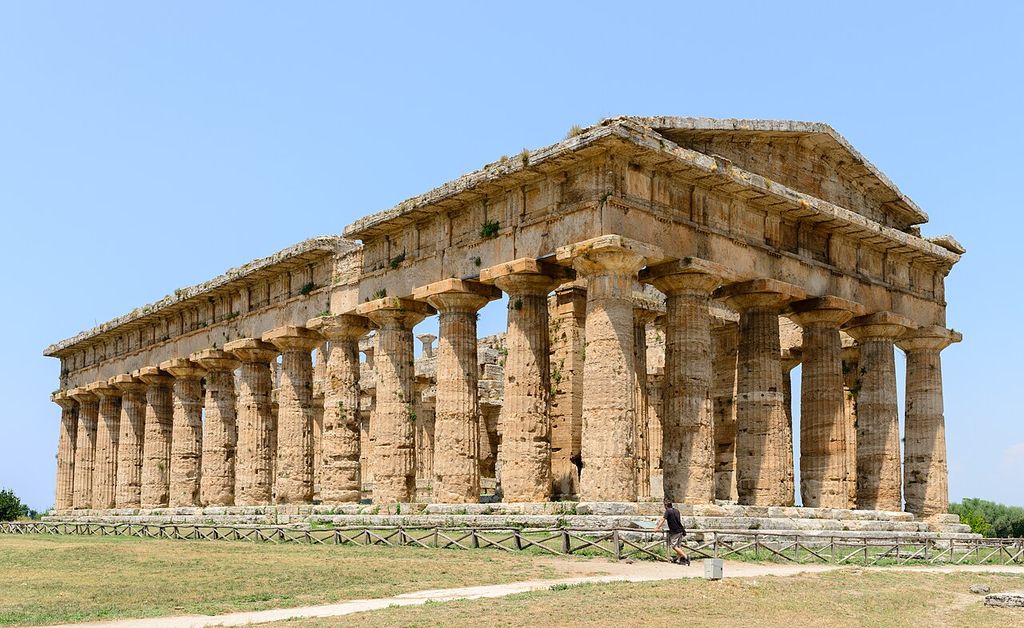 Doric temple at Paestum with closely spaced columns, a stone entablature and a surviving triangular pediment.