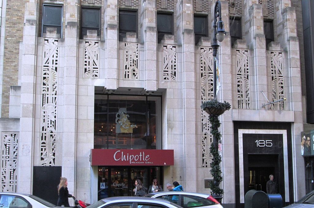 Vertical piers and patterned relief frame shopfronts and the entrance at 185 Montague Street.