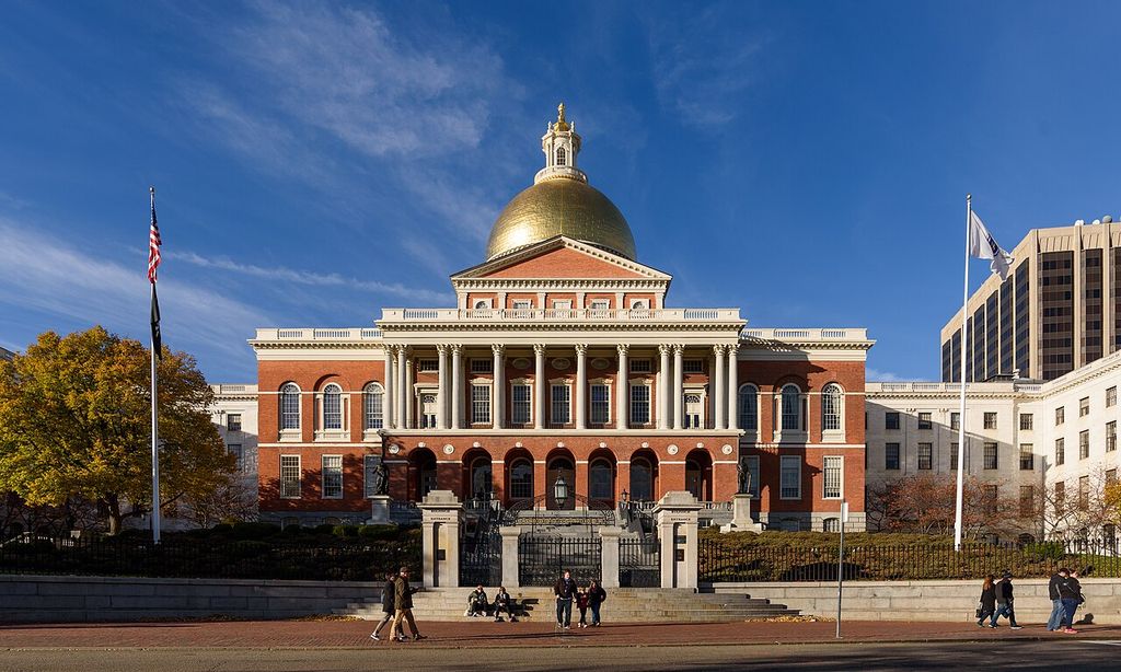 A symmetrical red-brick centre with columns, a pediment and a gold dome stands between pale wings.