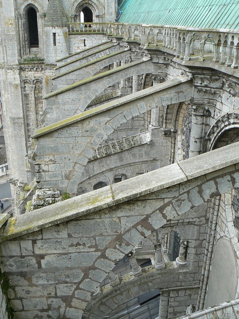 Arched masonry flyers cross the lower roofs between Chartres Cathedral’s high wall and outer supports.
