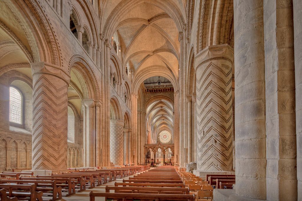 Patterned stone piers and round arcades supporting the rib-vaulted nave of Durham Cathedral.