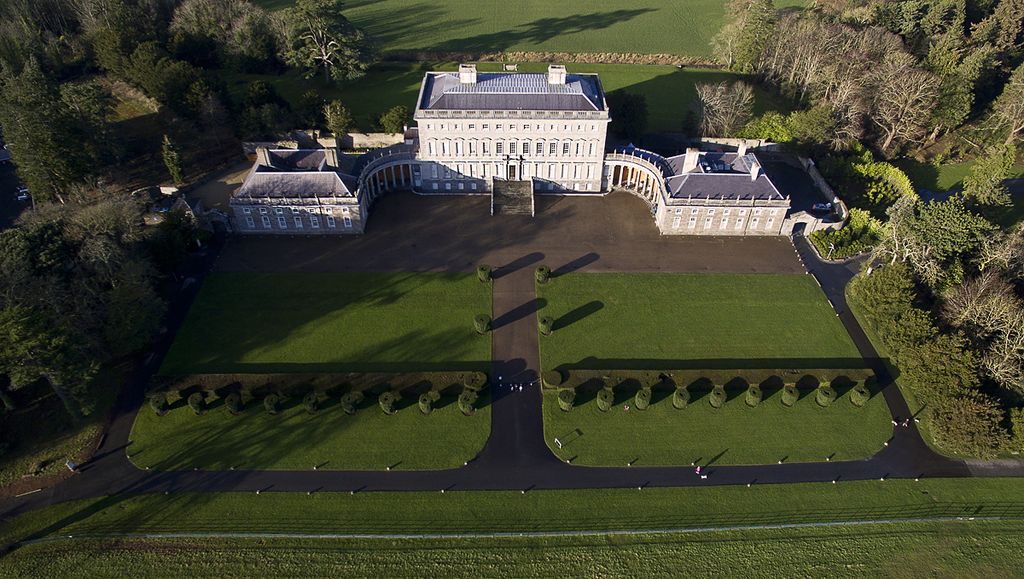 Curving colonnades link a large central house to two lower pavilions around a forecourt.