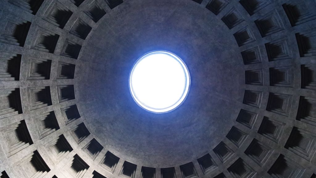 Concentric rows of coffers curving upward around the bright circular oculus of the Pantheon.