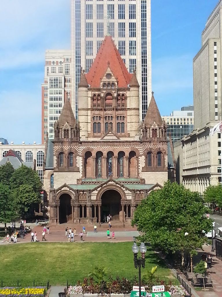 Patterned masonry and deep entrance arches rise toward a large central tower between smaller turrets.