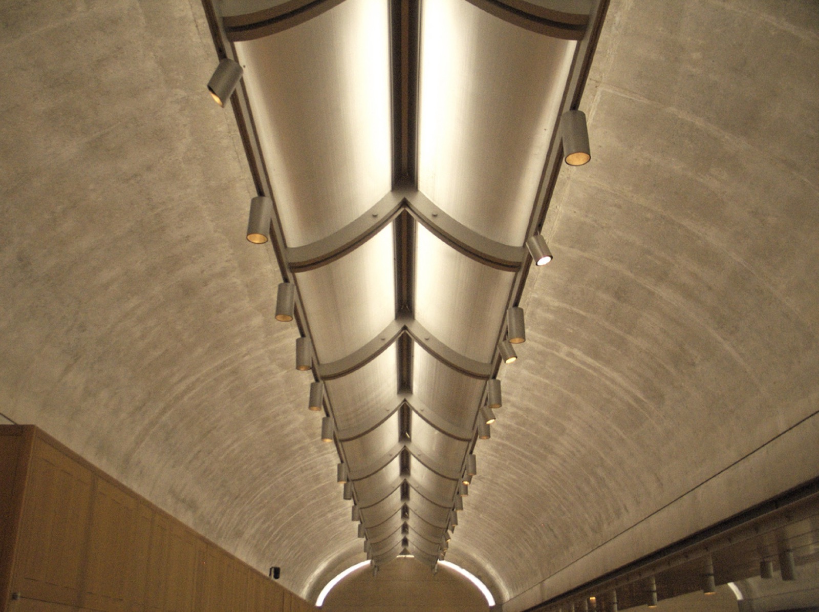 Interior Kimbell Art Museum vault with a narrow daylight slot and curved metal reflector running along its crown.