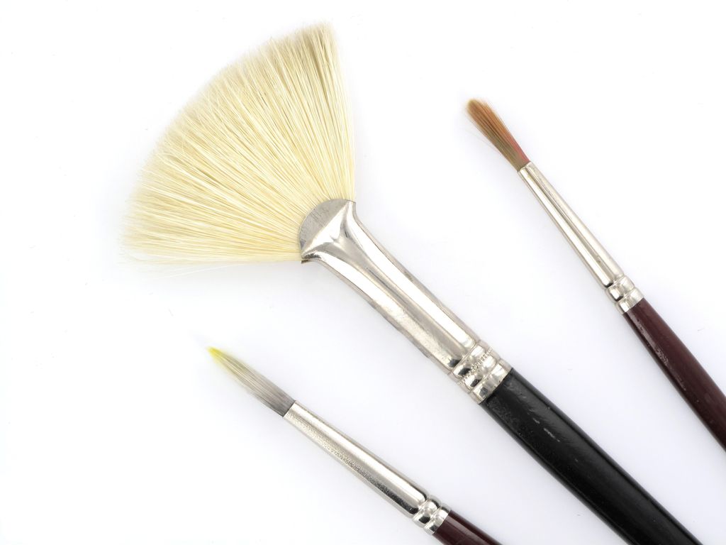Close view of several brush tips including fan, flat and pointed profiles.