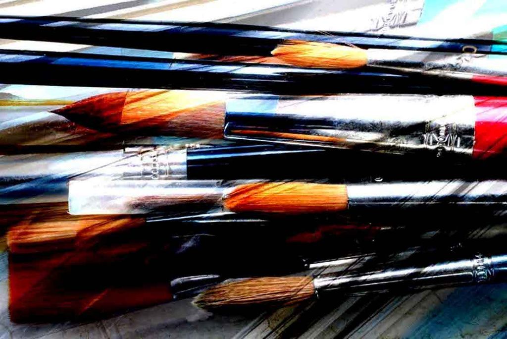 Assorted paintbrushes including broad flats and narrower pointed shapes.