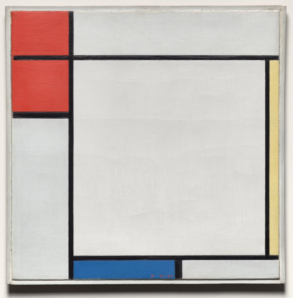 A square Mondrian painting divides pale fields with black horizontal and vertical lines, placing red rectangles at upper left, blue below and a narrow yellow strip at right.
