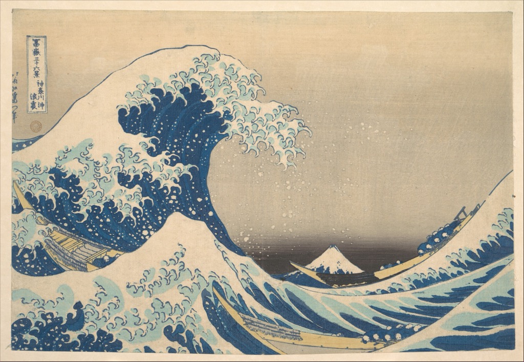 Hokusai colour woodblock print of a towering wave above boats with Mount Fuji in the distance