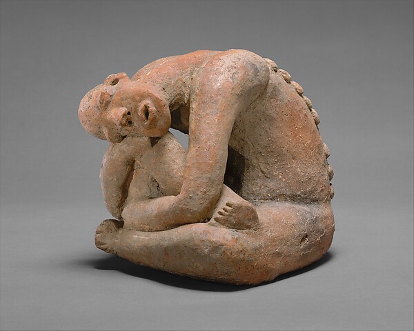 Middle Niger terracotta figure curled around one raised knee with patterned surface details.