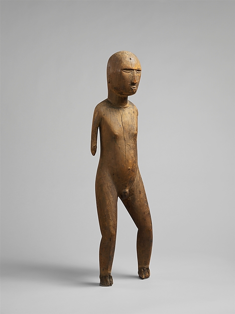 Compact Mangarevan wood male figure with bent knees and hands held to the torso.