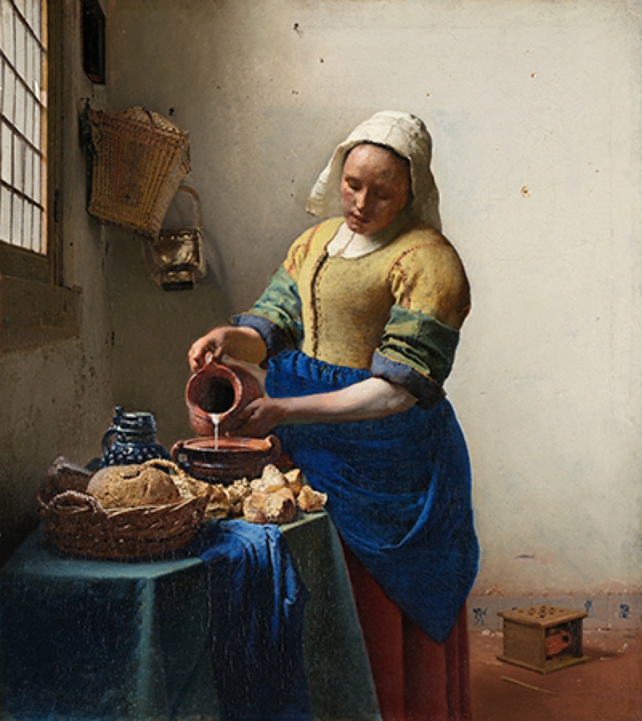 Vermeer's Milkmaid lit from a window at left, with light turning figure, bread and wall into volume.